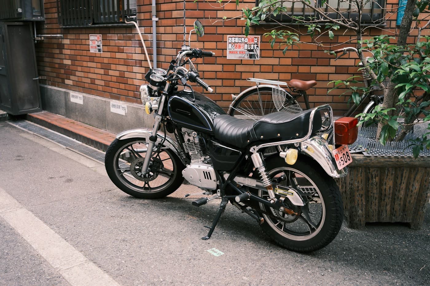 Motocicleta estacionada na calçada ao lado de um muro de tijolos