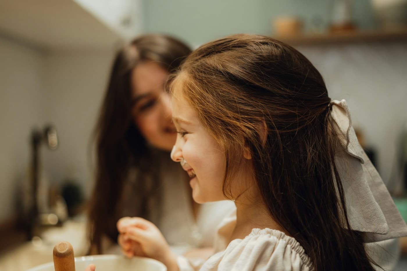 Mãe ajudando a filha a escovar os dentes