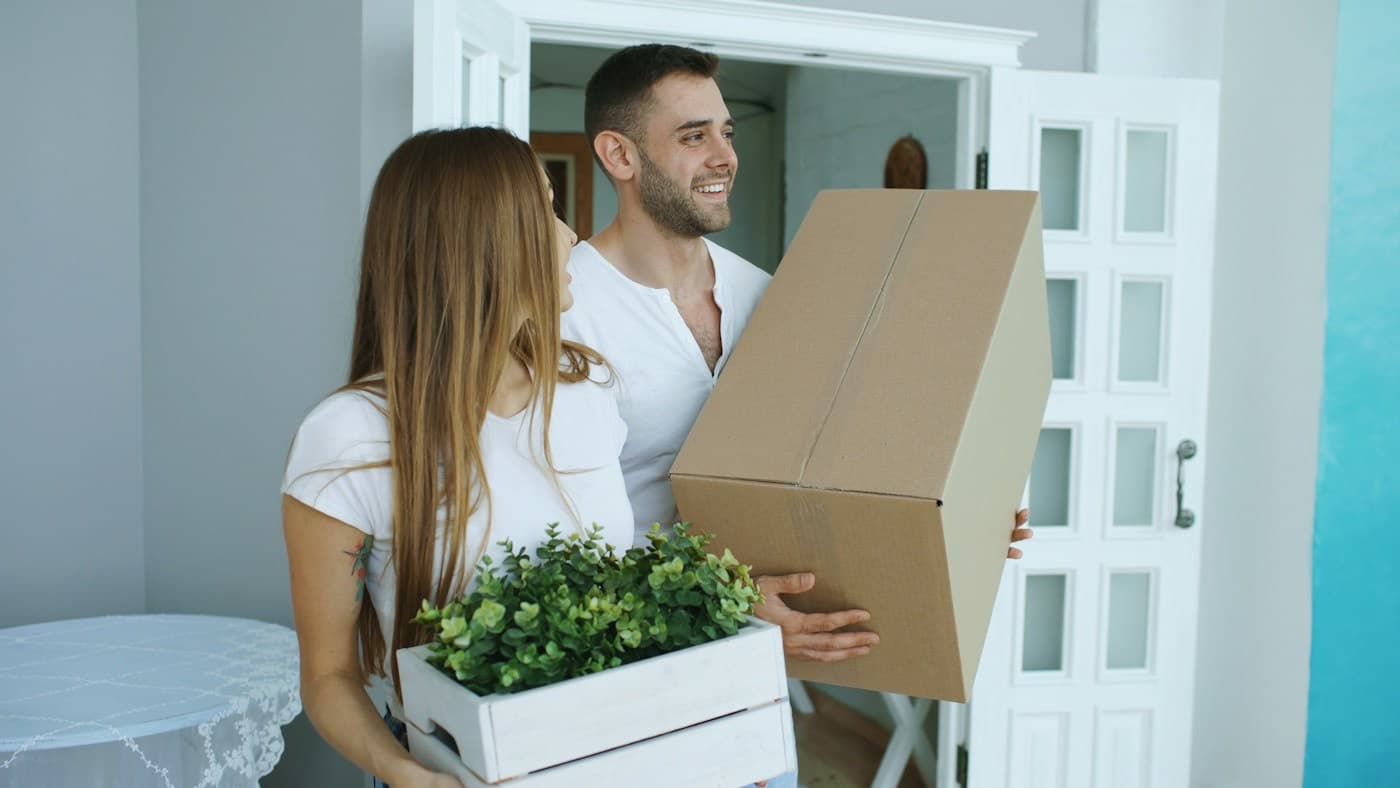 Casal carregando caixas de mudança para o novo lar