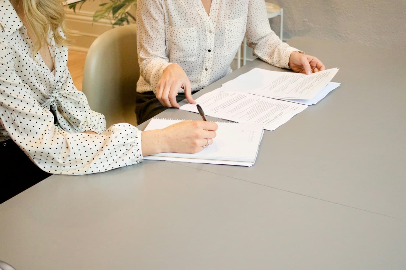 Profissionais revisando documentos de um contrato à mesa