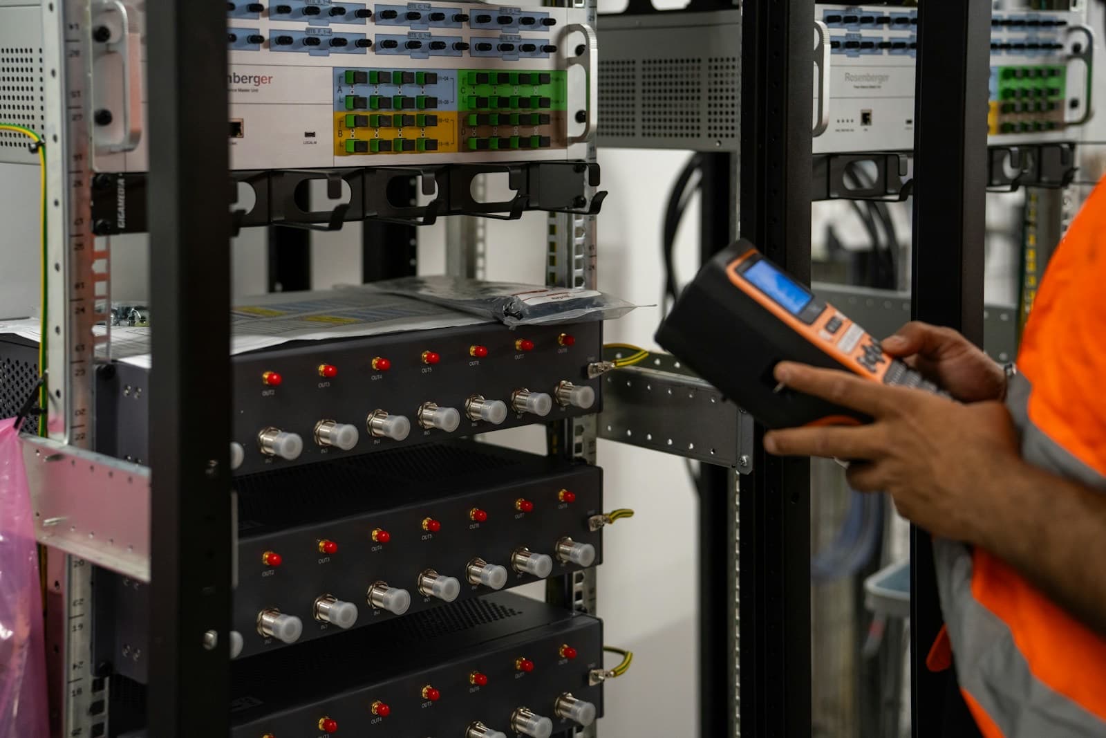 Técnico inspecionando racks de servidores com um equipamento de diagnóstico