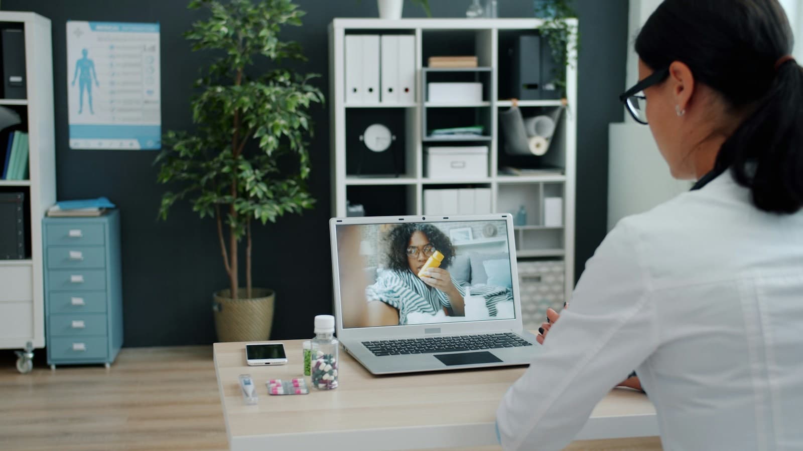 Médica atendendo uma paciente por videochamada no notebook